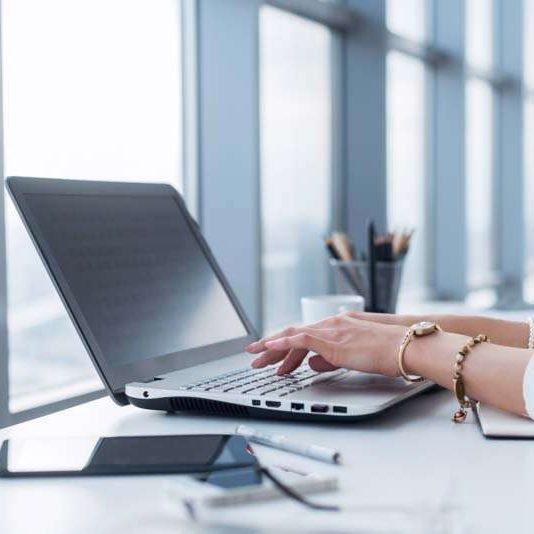 Female copywriter at her workplace, home, writing new text using laptop and Wi-Fi internet connection in the morning.